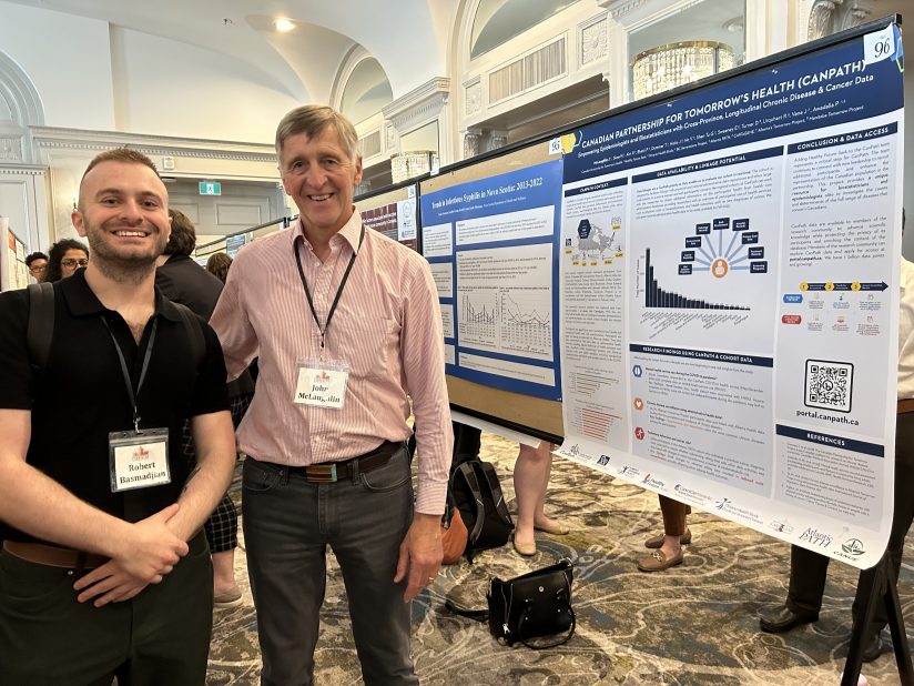 PhD Candidate Robert B. Basmadjian and Dr. John McLaughlin pose in front of the CanPath poster