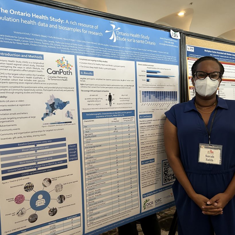 Sarah Salih poses with the Ontario Health Study poster