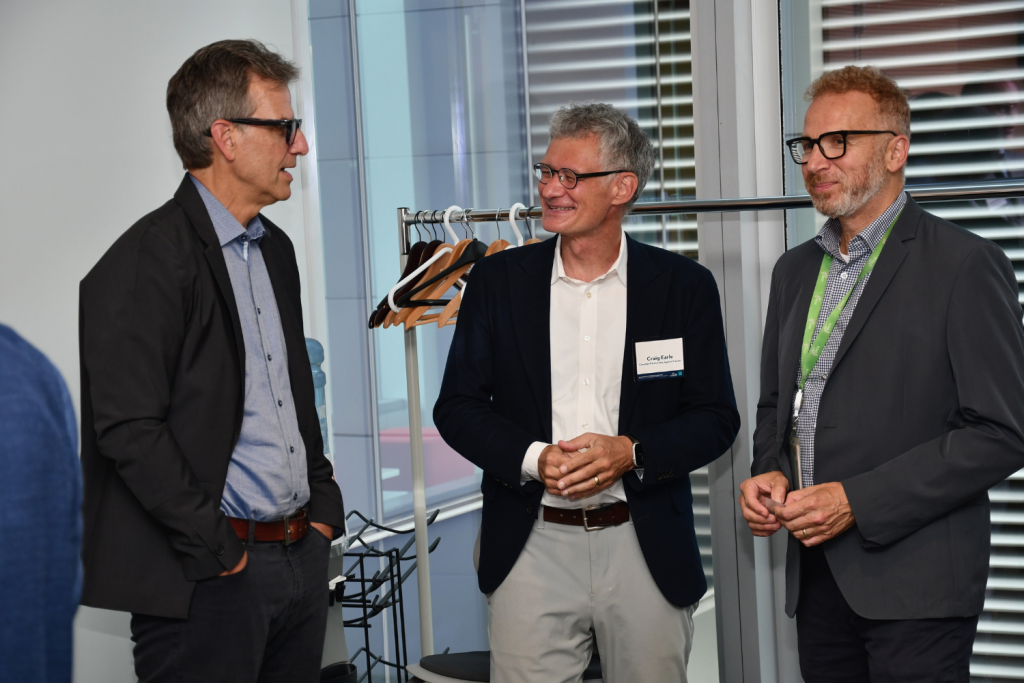 Michael Schull, Craig Earle, and Philip Awadalla chatting at the partnership event.