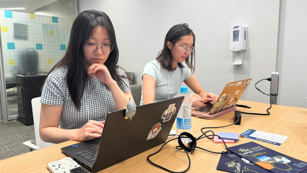 Joy Zeng and Amy Li working on their laptops at the workshop.