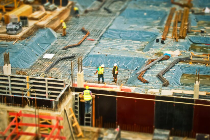 Construction workers wearing safety gear at a building site, representing how workplace exposures and healthy environments contribute to colorectal cancer prevention efforts.