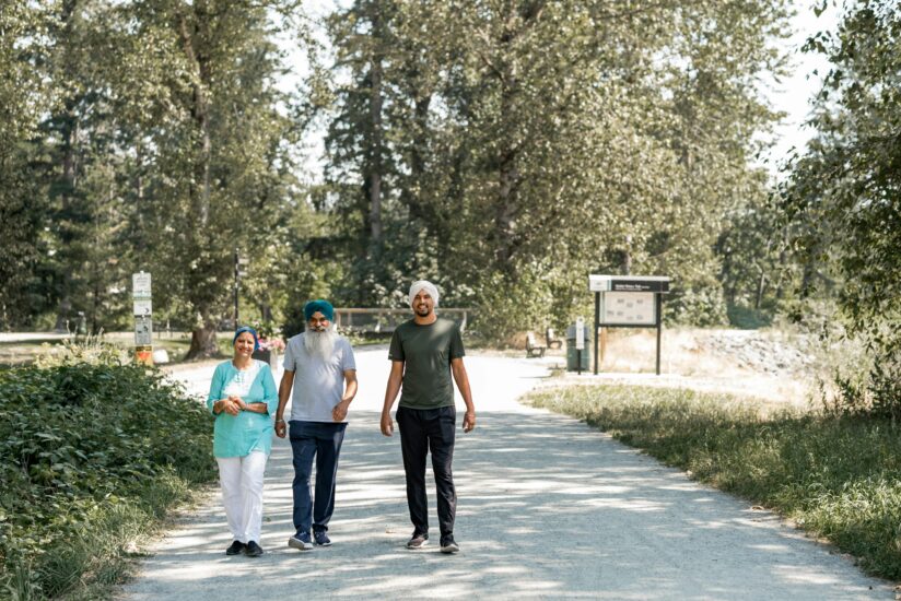Three people walking on a concrete road.